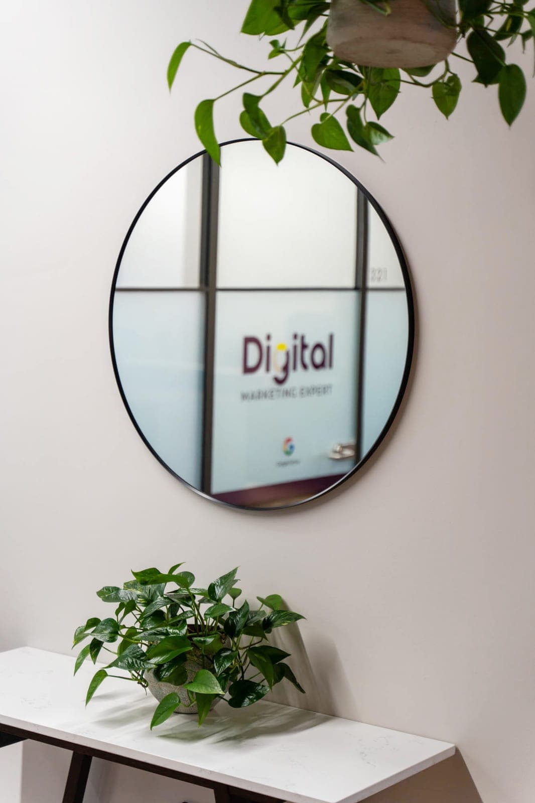 A mirror in the Digital Marketing Expert office reflecting the branded studio door