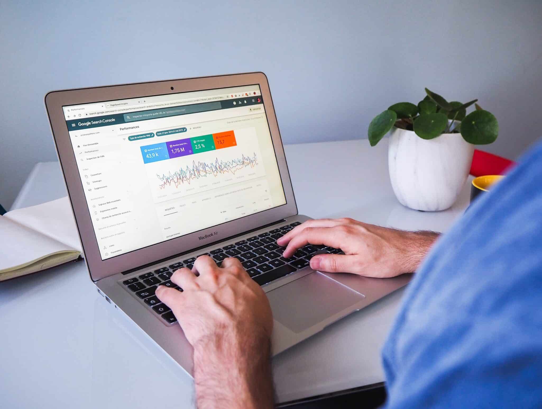A person working at a laptop showing a colour-coded analytics dashboard.