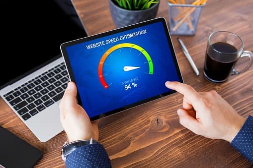 A tablet on a desk showing a website speed optimisation dial reading 94 percent.