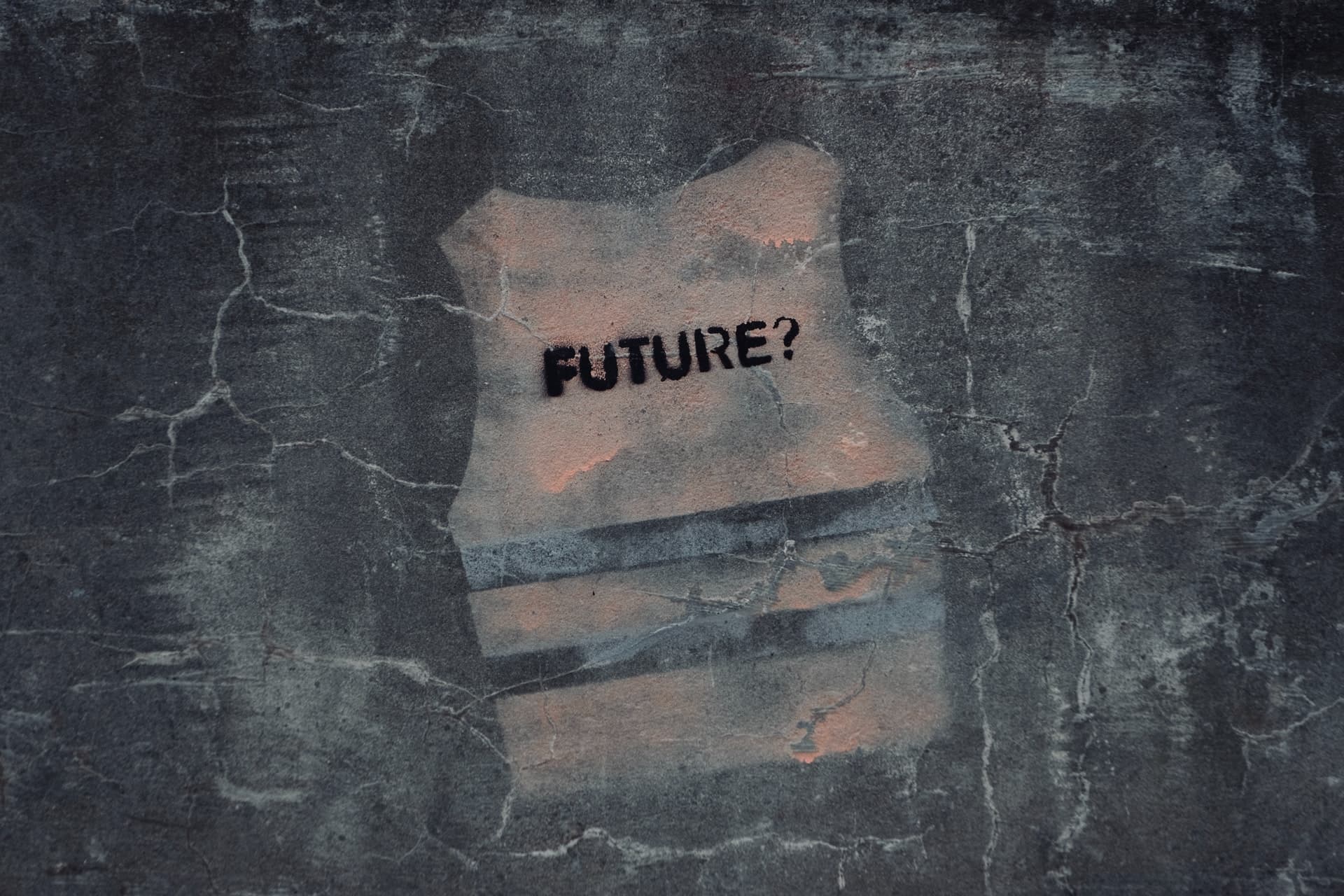 The word Future with a question mark, stencilled on a weathered concrete wall.