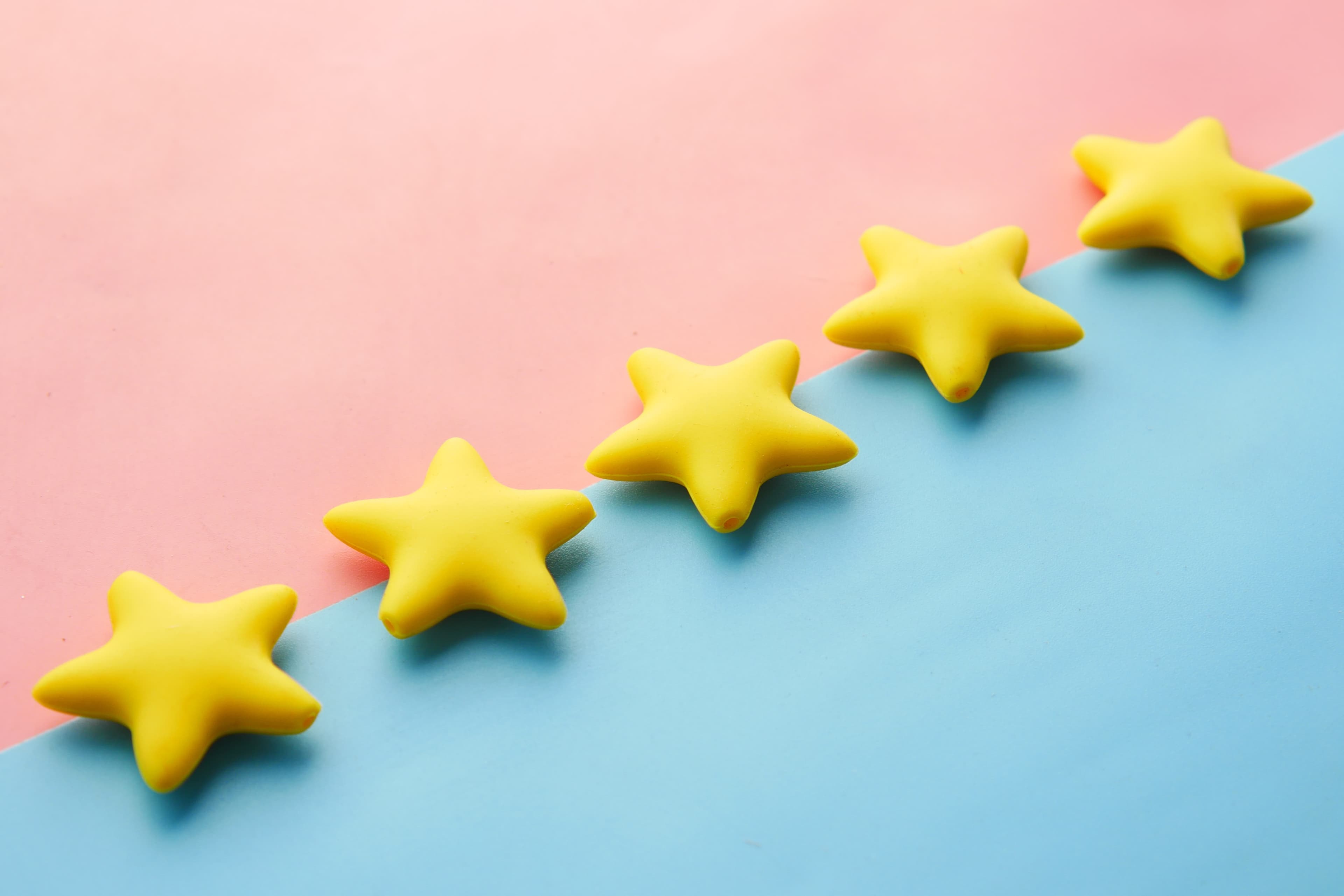 Five yellow stars in a row on a pink and blue background, representing a five star rating.
