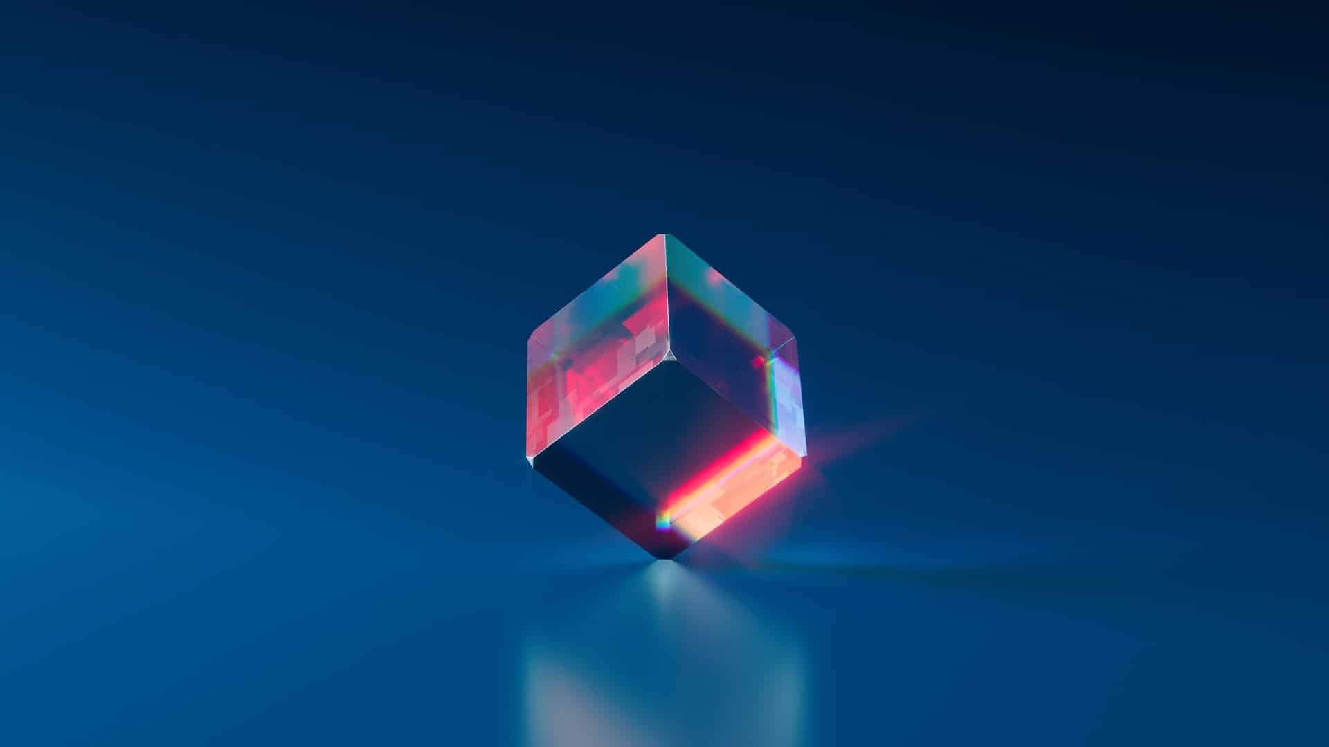 A glowing translucent cube floating above a reflective blue surface.