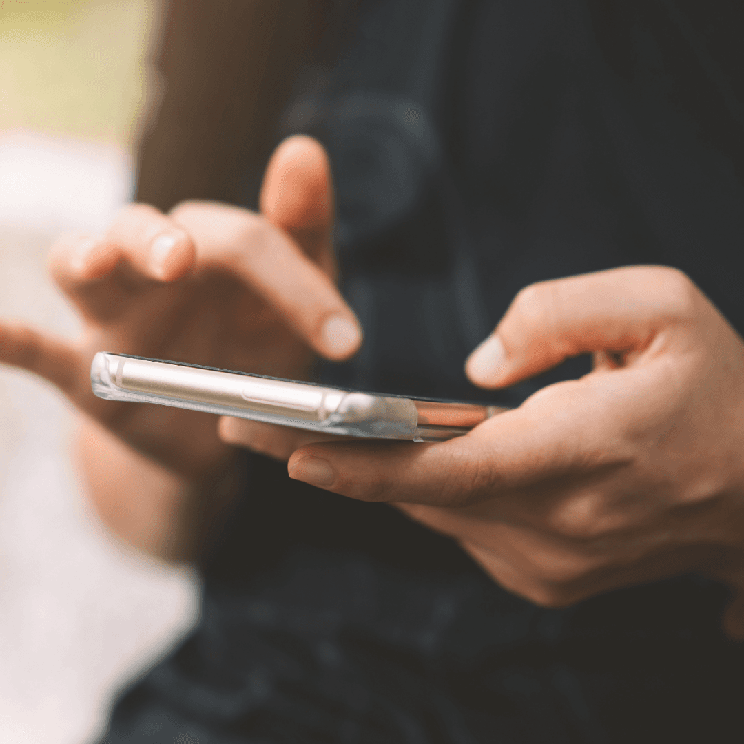 Close-up of a person using a smartphone with both hands.