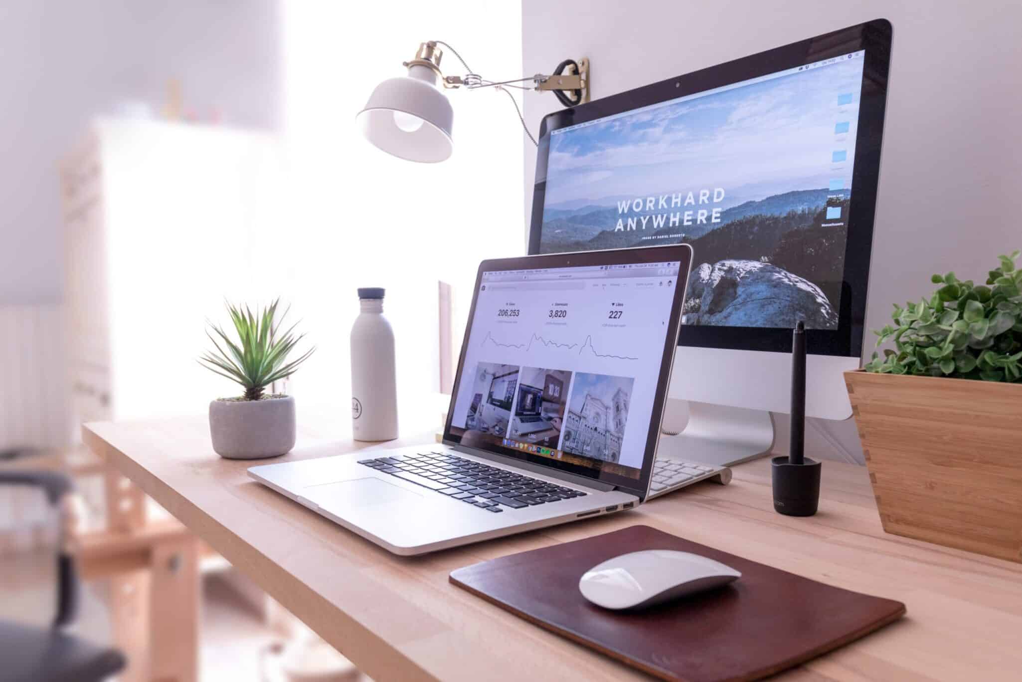 A laptop and monitor on a tidy home-office desk, both showing the same website design.