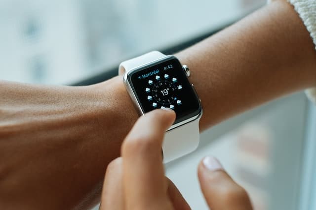 A person tapping the screen of a smartwatch on their wrist.
