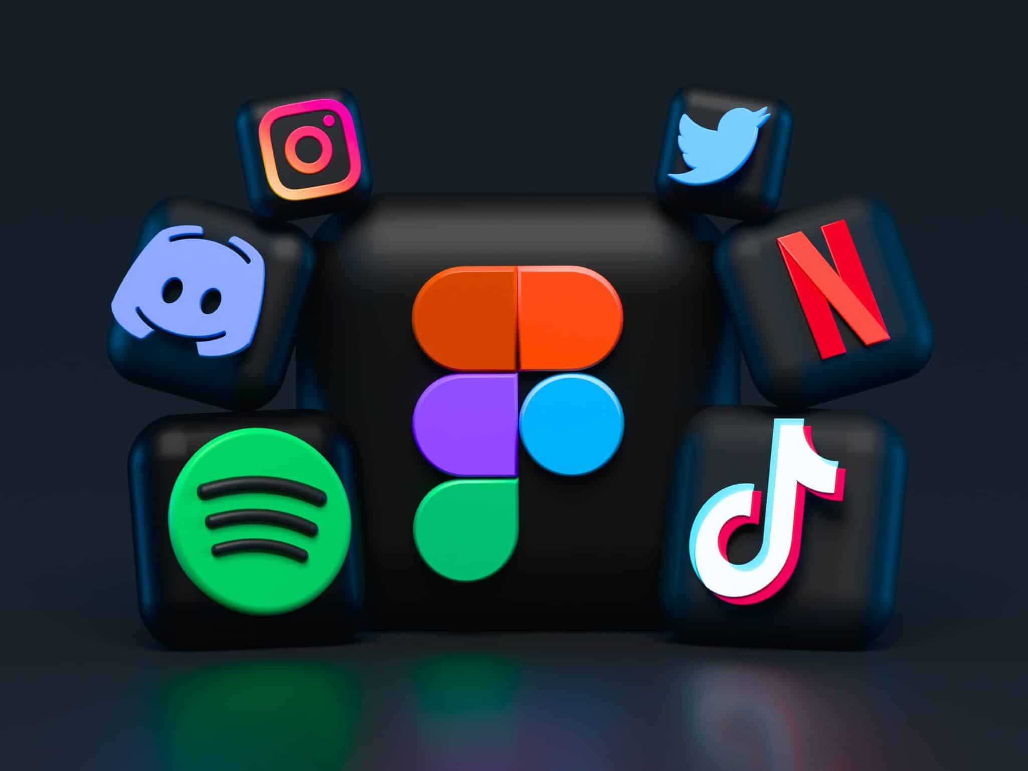 Three dimensional app icons for Figma, Instagram, Spotify, TikTok, Netflix, Discord and Twitter on a dark background.