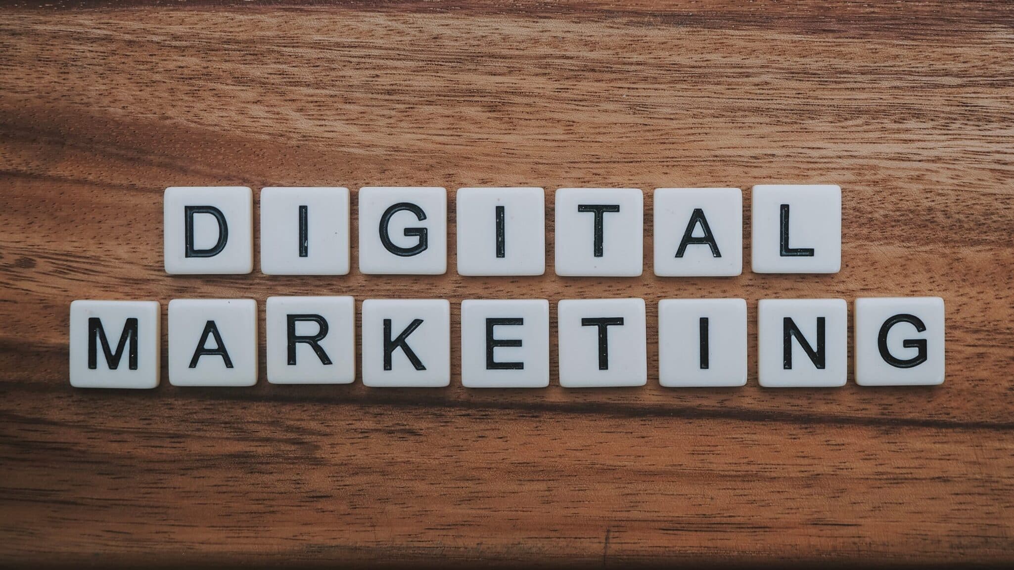 Letter tiles arranged on a wooden surface spelling Digital Marketing.
